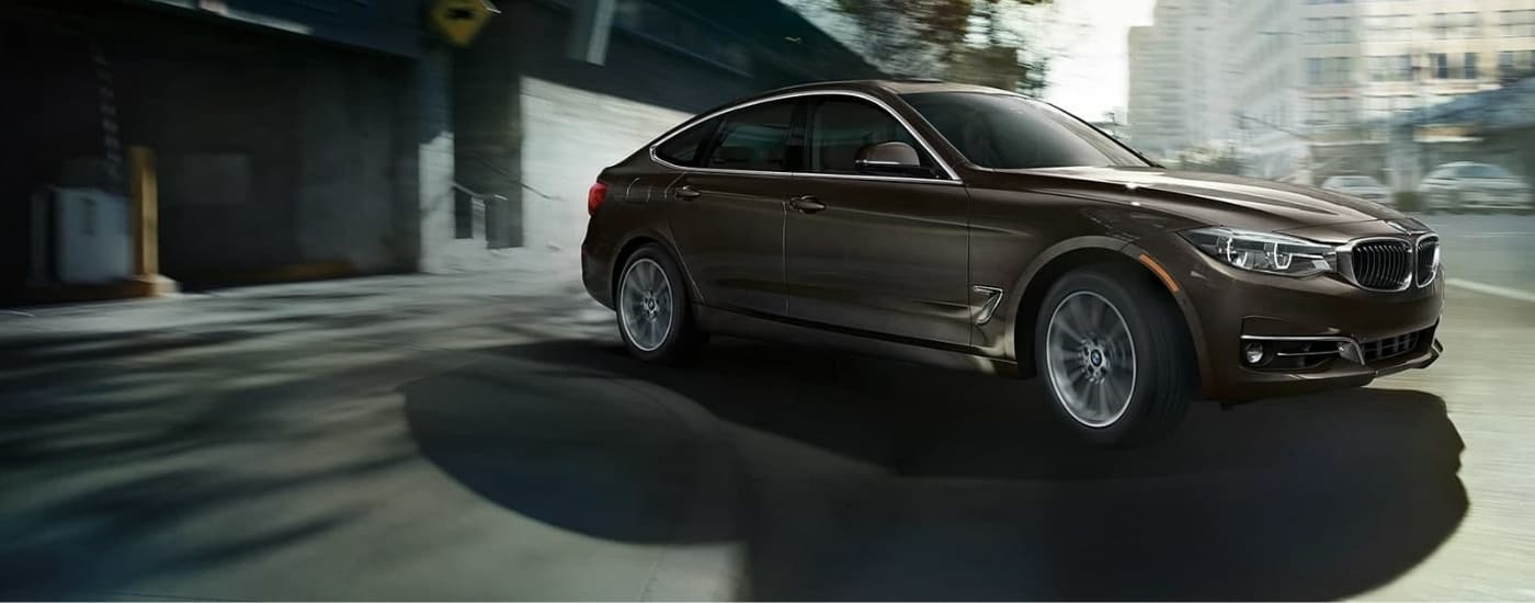 A brown 2019 BMW 3 Series Gran Turismo leaving a parking garage.