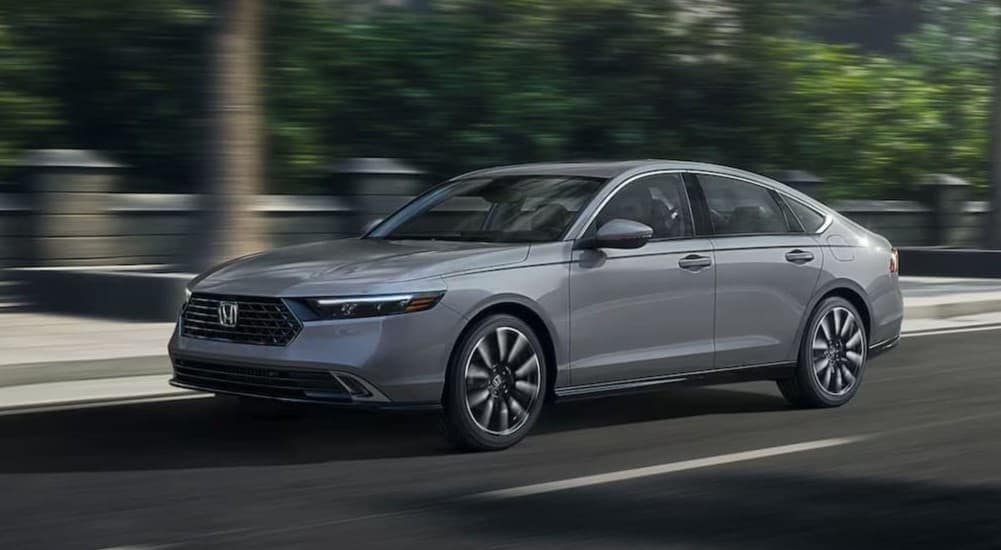 A gray 2025 Honda Accord Hybrid driving to a car dealer near Cumming.