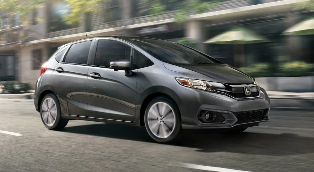 A gray 2020 Honda Fit is shown driving on a city street.