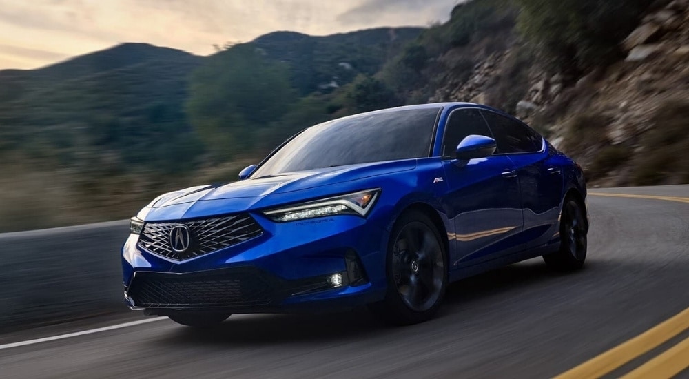A blue 2023 Acura Integra A Spec is shown driving to a dar dealer near Sandy Springs.