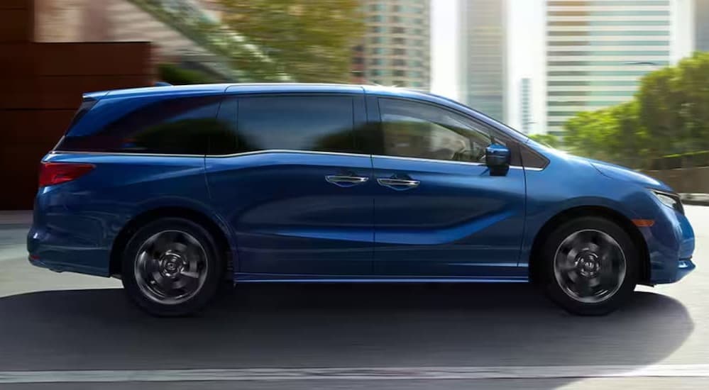 A blue 2024 Honda Odyssey driving to view used cars for sale near Durham.