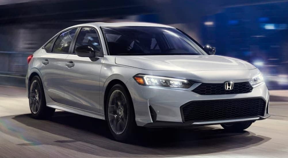 A gray 2025 Honda Accord Hybrid driving to a car dealer near Cumming.