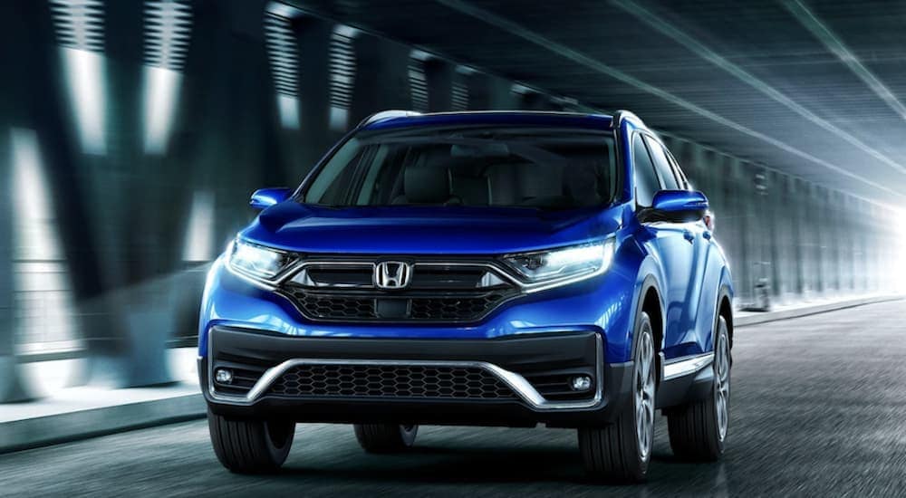 A blue 2022 Honda CR-V driviing in a tunnel.